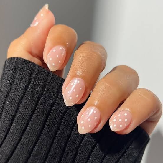 Subtle nude nails with delicate white polka dots