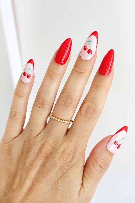 Red and blush cherry nail art with delicate gold ring
