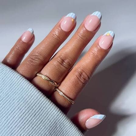 Blue-white French tip with tiny gold star detail on almond nails