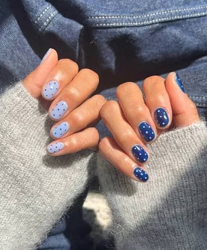 Navy blue and light blue polka dot nail art on short square nails
