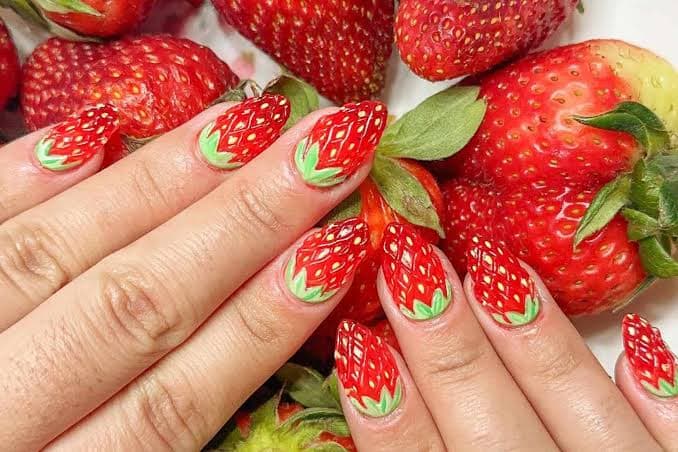 Intricate strawberry nail art on almond-shaped nails